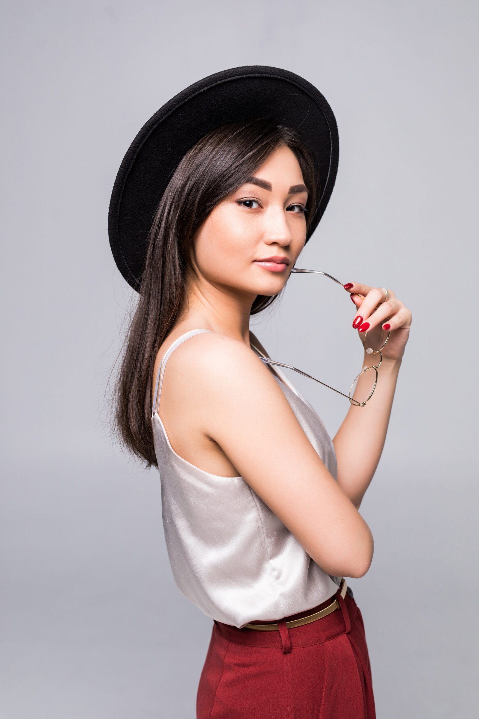 Young Asian woman smiling in summer hat over white background